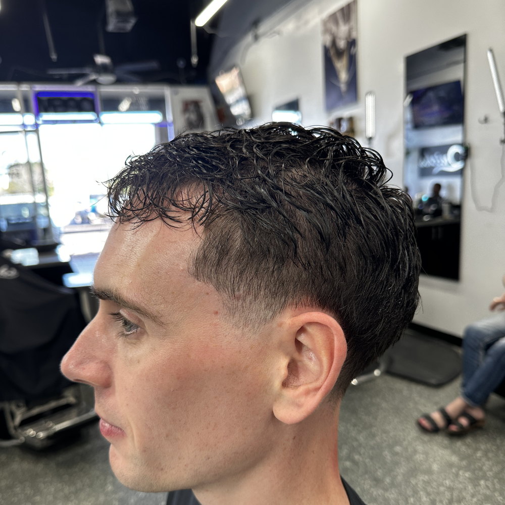 A curly top with a clean taper through the sides