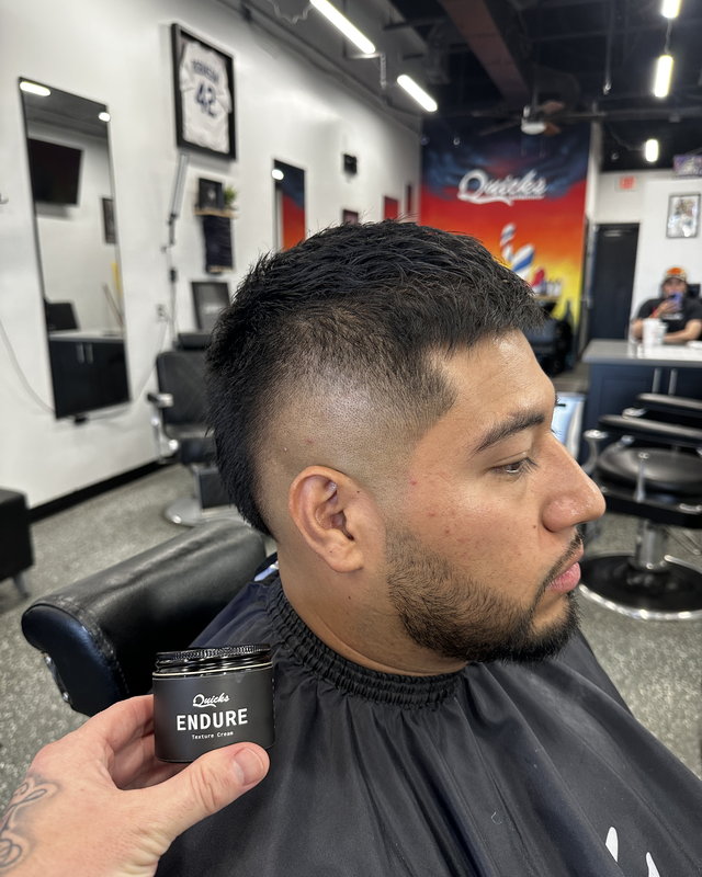A mid fade, finished, with the shop behind