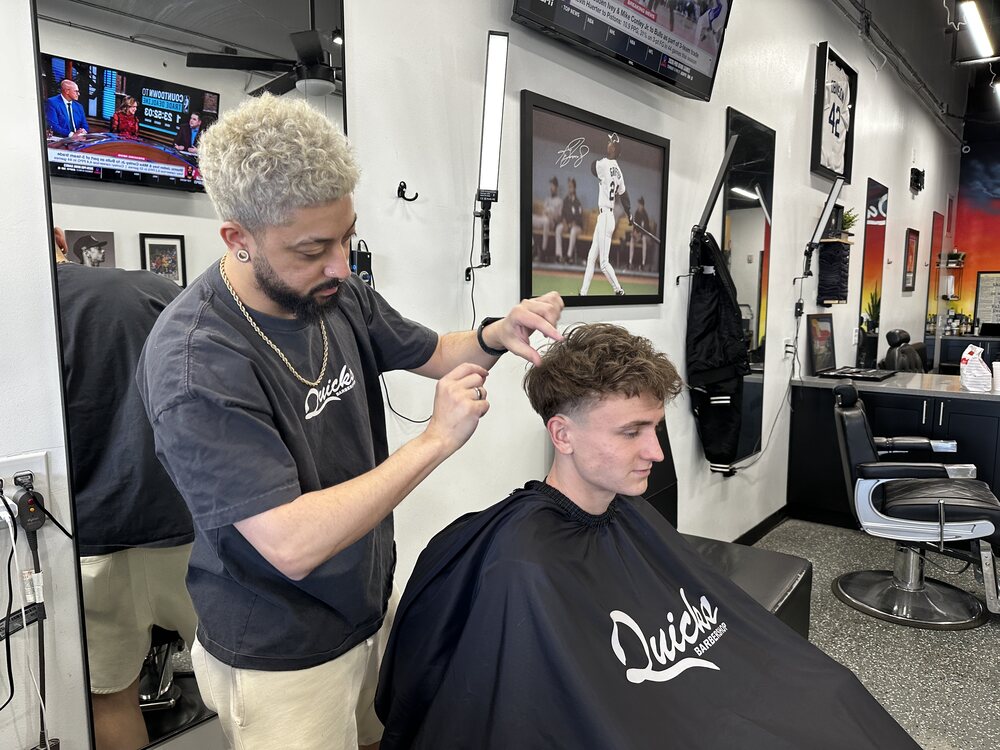 Jay cutting a client's hair at Quicks Barbershop